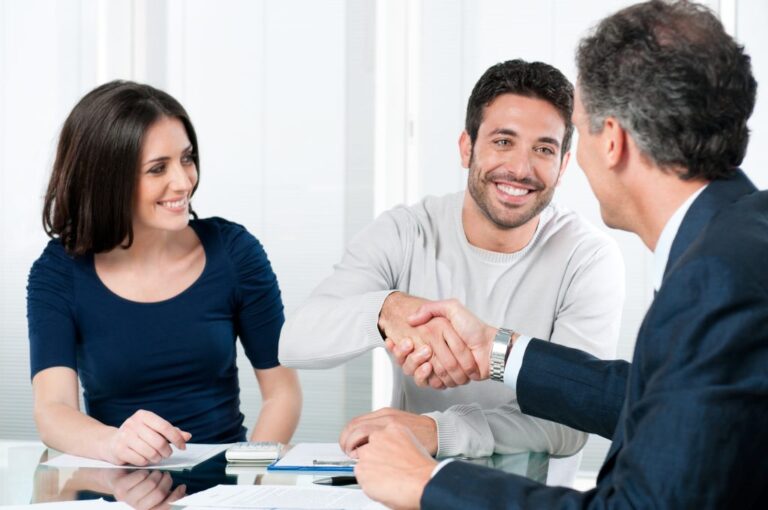 couple and realtor with the man and realtor shaking hands | Real Estate Glossary