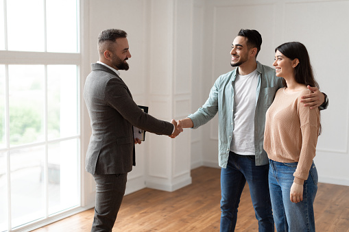 couple shaking hands with realtor